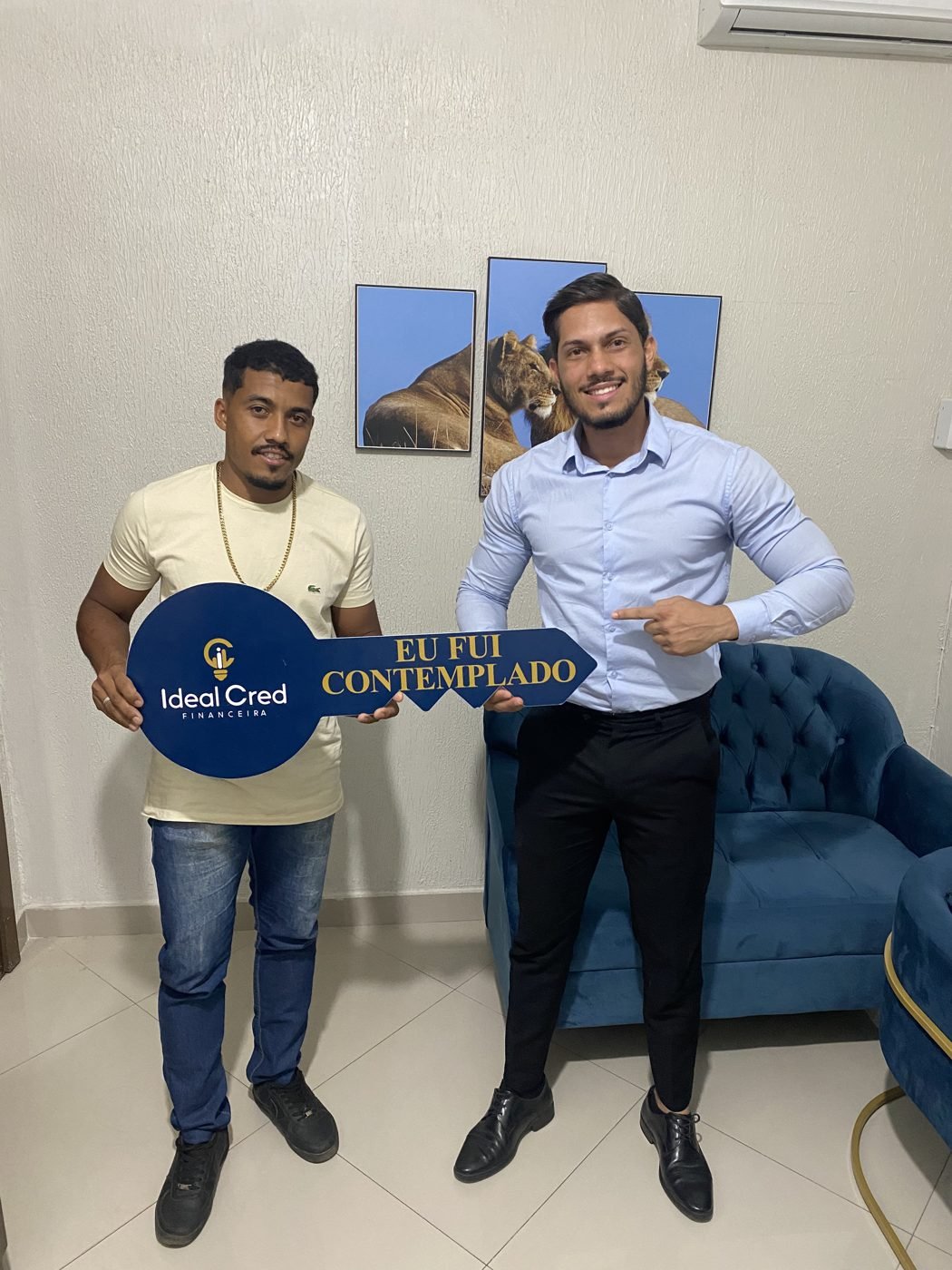 Cliente contemplado com a chave simbólica ao lado do consultor